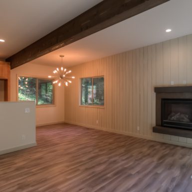 Open concept floor plan including living room and dining area. Fireplace on one wall.