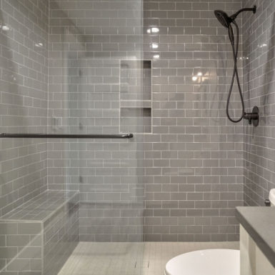 shower area with top to bottom dark subway tile