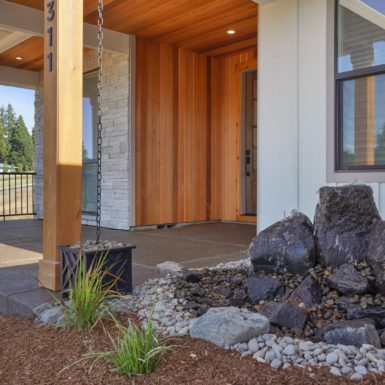 Exterior Front Entrance Area With Dark Stone Fountain And Light Beautiful Wood Accent Entry