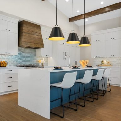 Kitchen With White Waterfall Countertop Pendant Light Custom White Cabinets