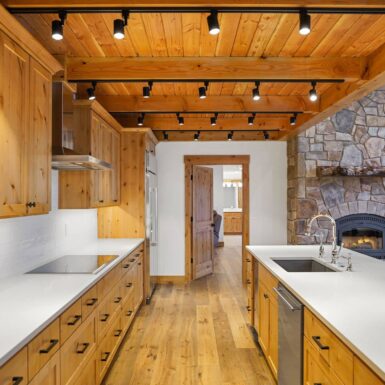 Kitchen white counter top and spot lights with view to a beautiful stone fireplace