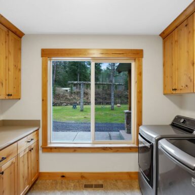 Laundry room with stained wooden cabinets and trim equipped with washer and dryer