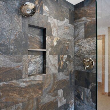 Primary bathroom slate looking walk in shower with shelves and chrome fixtures