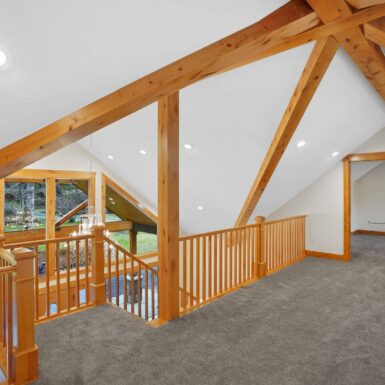 Second level landing with exposed beams and posts and beautiful staircase rail with clear stain wood trim